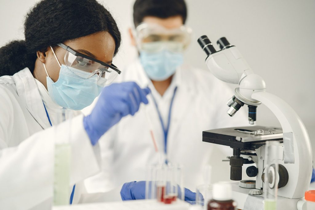 A female and male chemist observing chemical product in a test tube