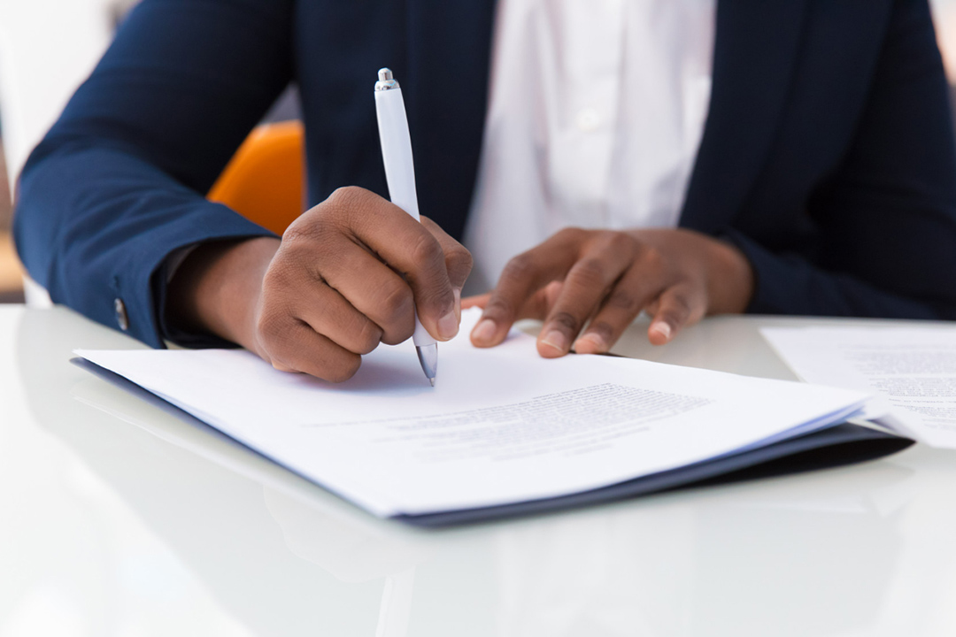 The-impact-of-government-regulations-on-speciality-chemicals A man in a suit signing a regulations sheet of paper